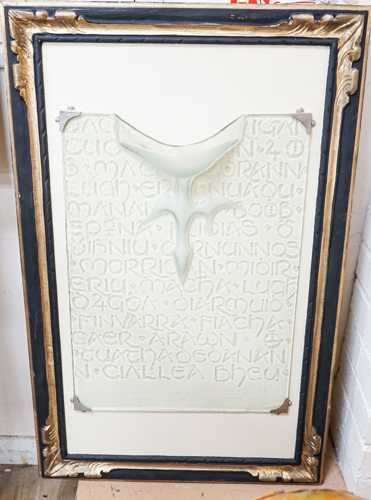 An Irish glass wall fixture moulded with Gaelic script, 56 x 41cm